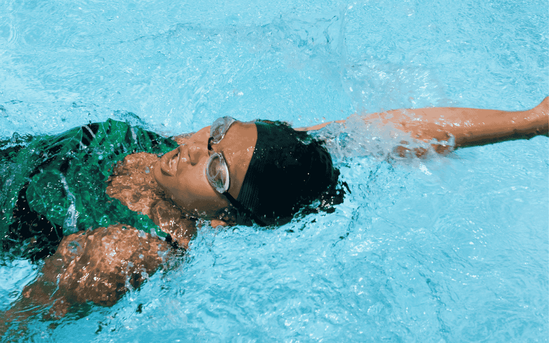 Frau im Wasser rückenschwimmend. Ein Arm ist ausgestreckt, das heißt sie ist in der Gleitphase